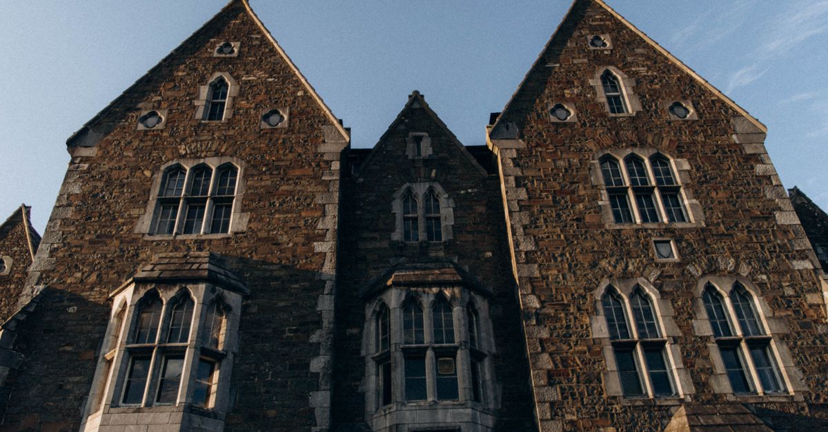 Low-angle photo of a stone building exterior showcasing gothic architecture and pointed gables.