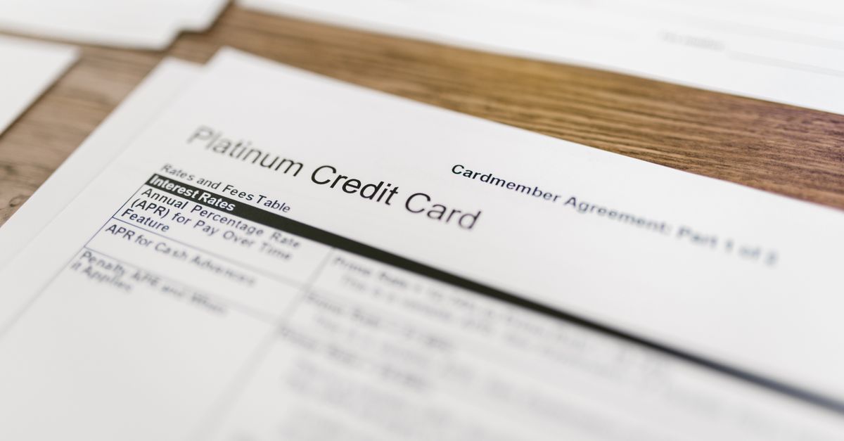 Close-up of a platinum credit card agreement document on a wooden desk.